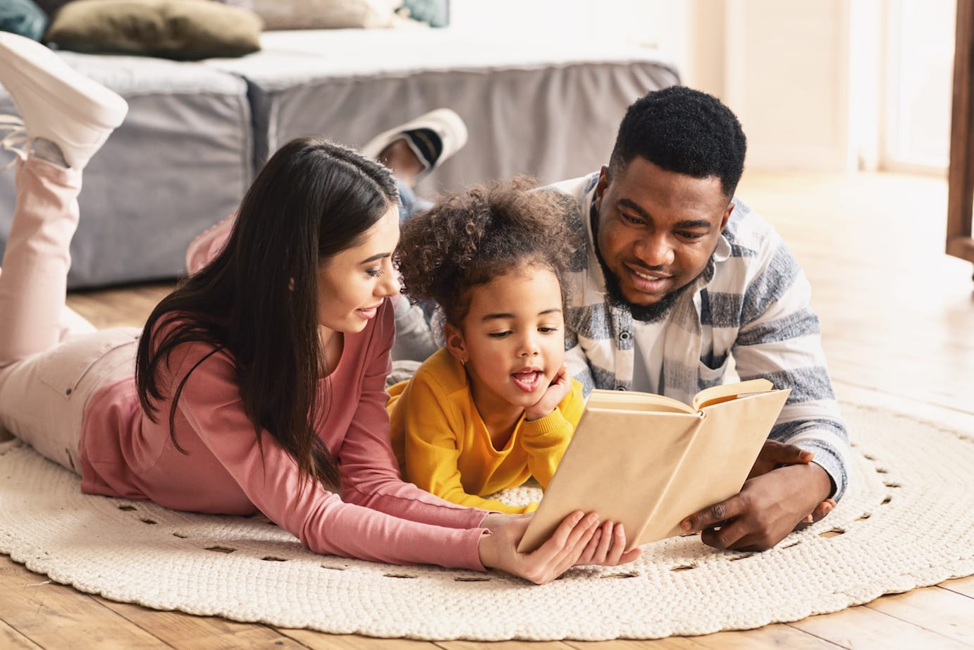 a family reading a book on the floor