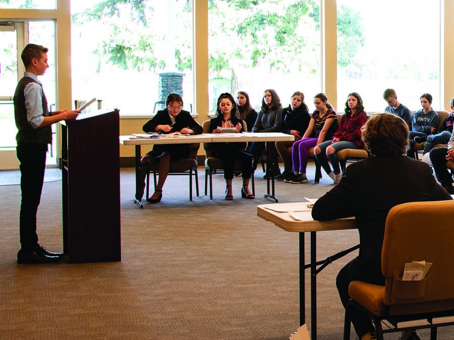 A student presenting a rhetorical speech to his peers
