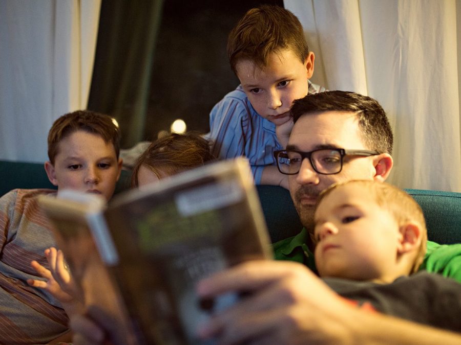 A homeschool dad reads aloud to his four kids