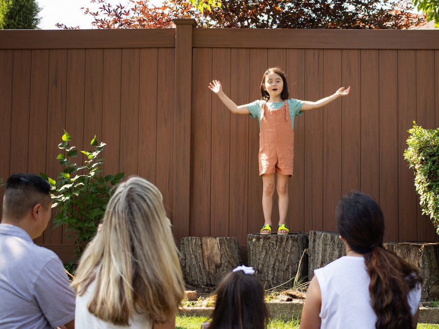 a girl gives a presentation to her family outside
