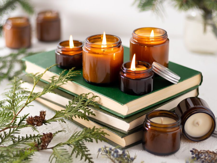 A set of different aroma candles in glass jars on a white background