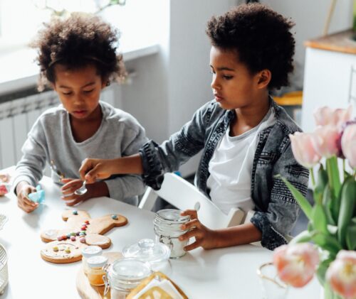 A pair of siblings make gingerbread men together - a fun Christmas activity for kids!