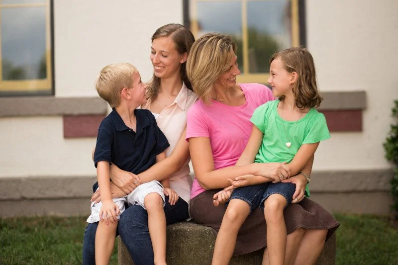 Homeschoolers sit together outside.