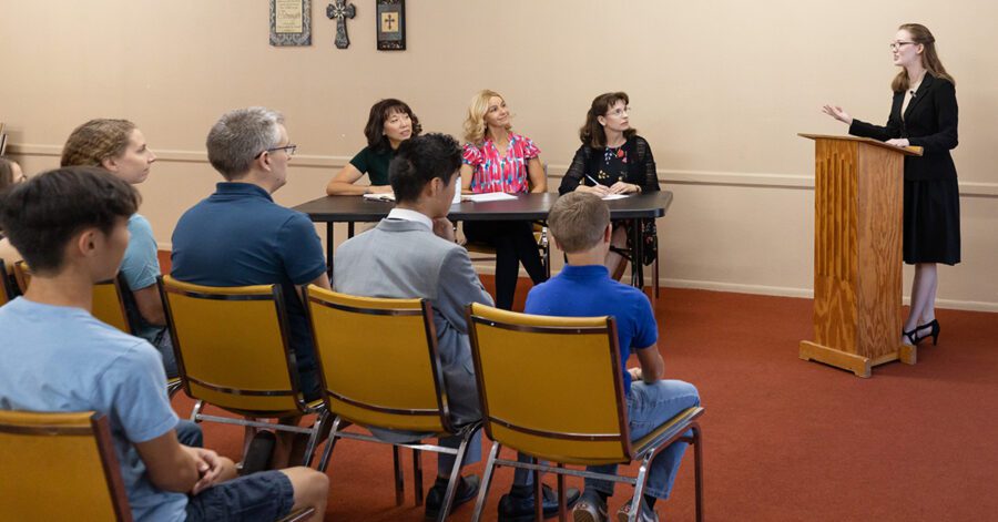 Homeschool senior presenting in front of a panel of parents and audience.