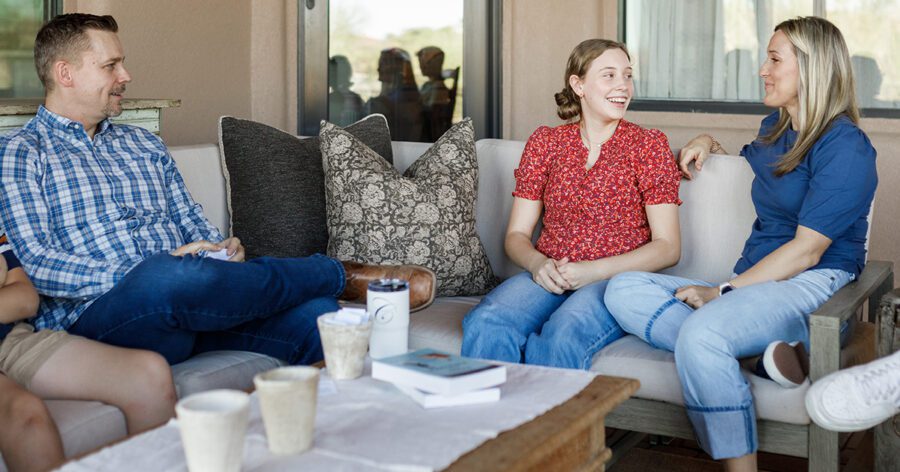 Homeschool parents sitting with their daughter, helping shape her future.