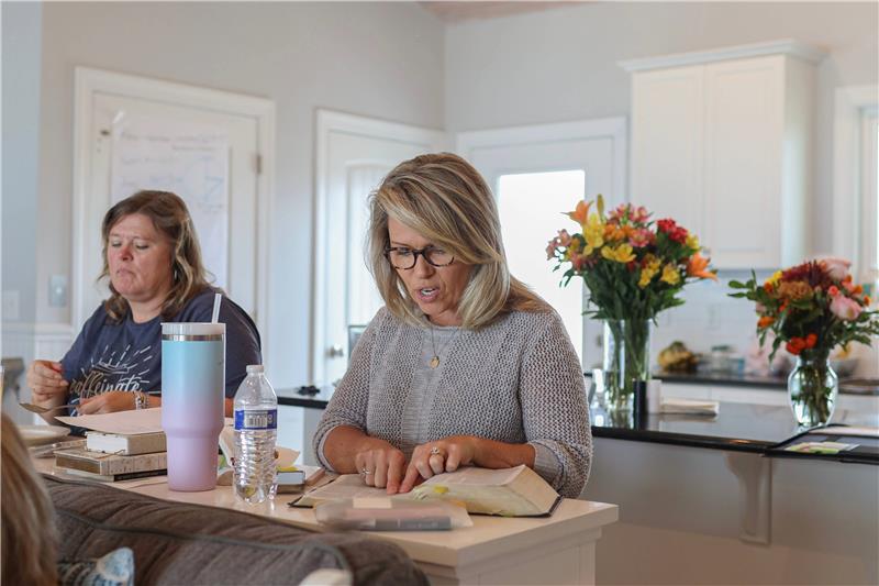 Two homeschool moms sitting at a table reading